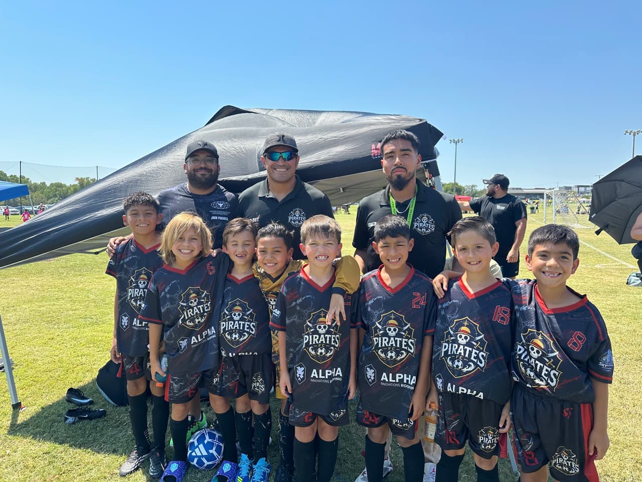 Pirates FC youth players and coaches posing together at a tournament